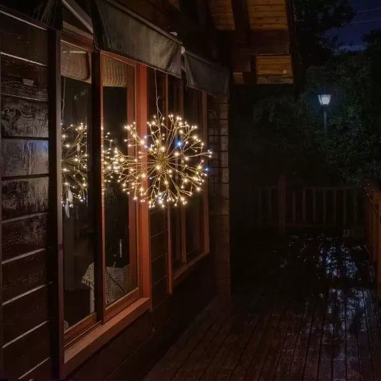Decorative string lights hanging on a window of a wooden cabin at night.